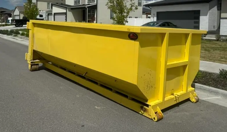 Residential dumpster rental by Space Coast places yellow rolloff dumpster for household cleanup project