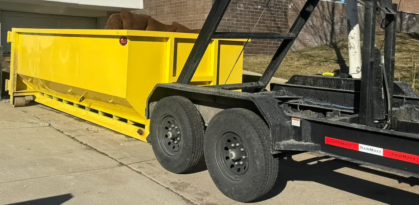 Space Coast Dumpster Rental yellow dumpster loaded with bulky junk during residential haul away setup