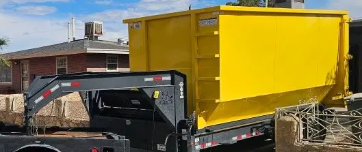 Space Coast Dumpster Rental gooseneck trailer transporting yellow roll-off dumpster to local home site