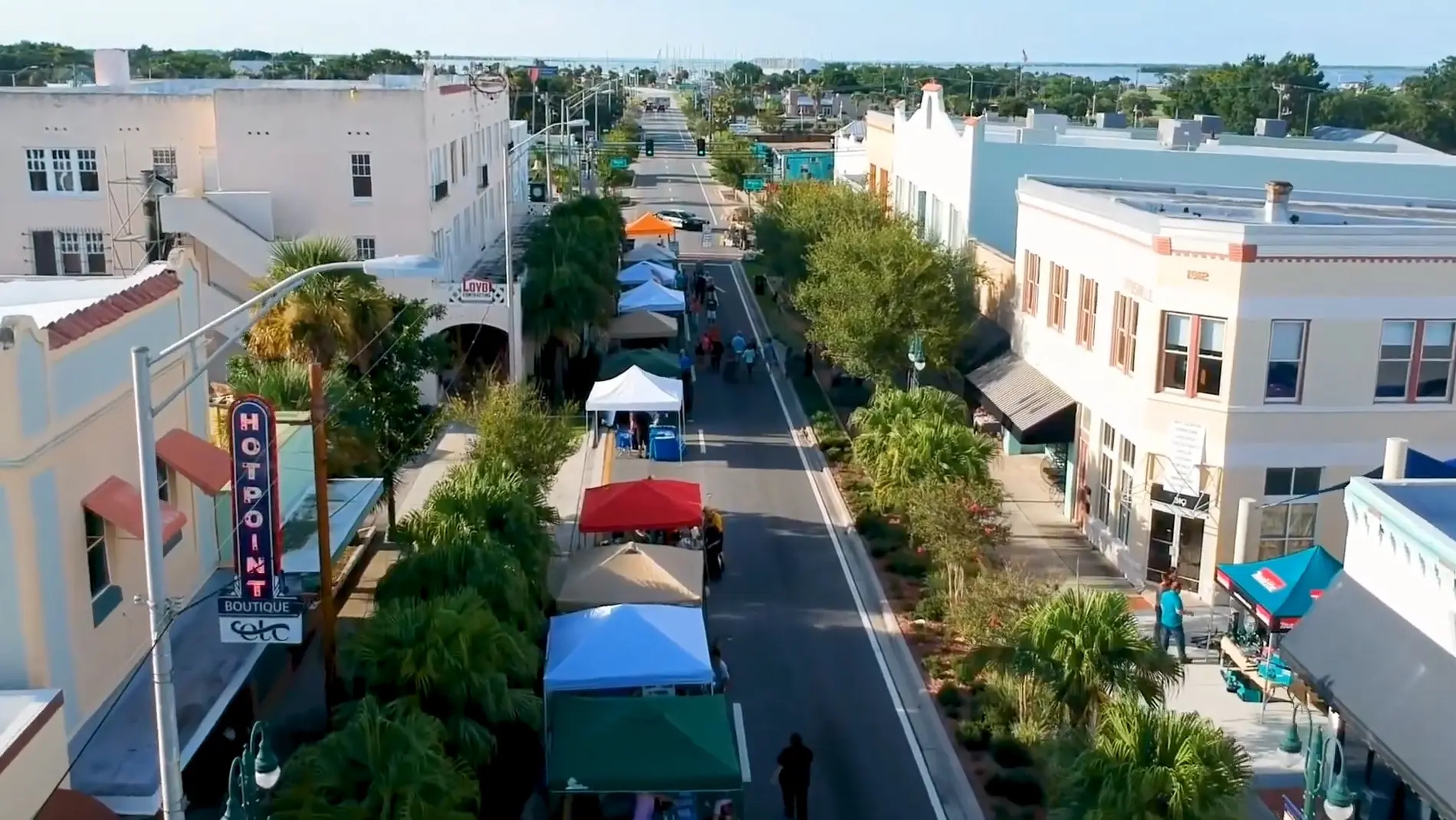 Titusville hosts a vibrant street market lined with vendor tents and historic buildings as seen from above by Space Coast Dumpster Rental